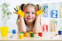 Nursery age pupil experimenting with paint