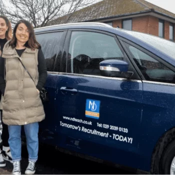 Two New Directions employees stand next to a car full of Ukraine aid.