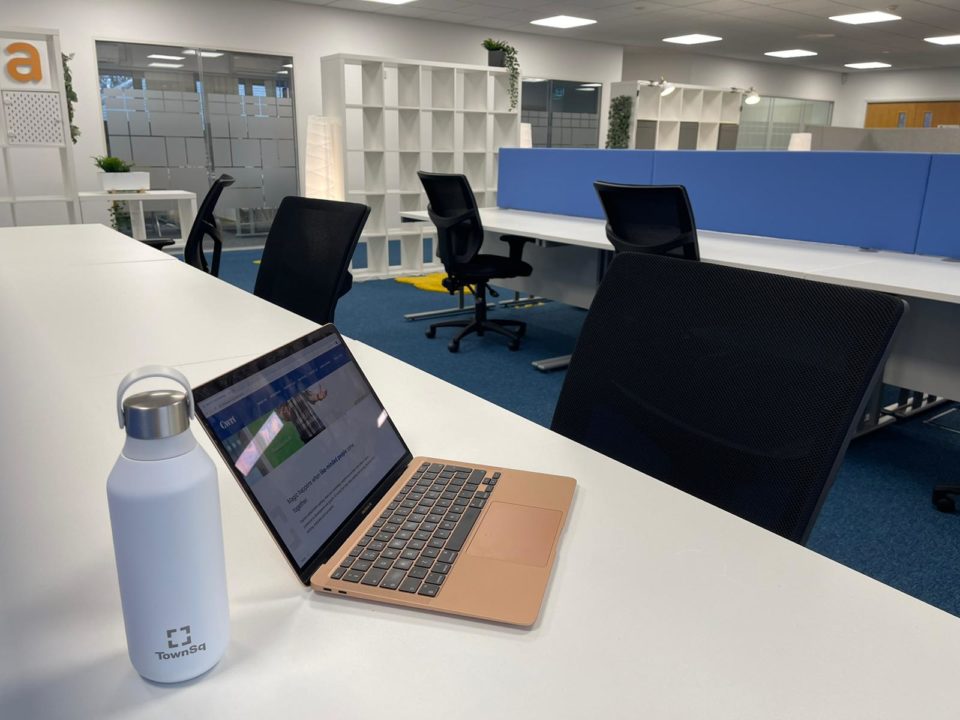 A water flask and laptop are on a table.